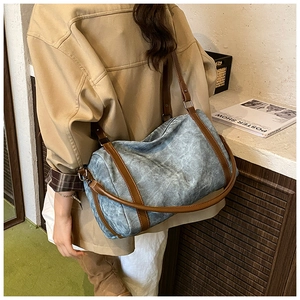 Detail of vintage denim Boston bag with leather trim and adjustable shoulder strap