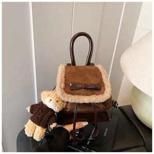 Close-up of brown bucket backpack with faux fur trim, leather bow and cute bear charm