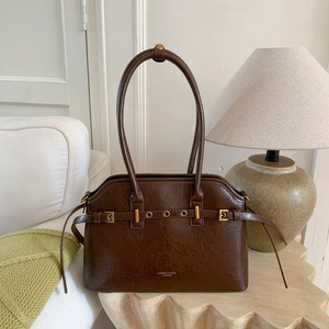 Gros plan sur un sac cabas vintage en cuir marron avec détails et boucles dorées