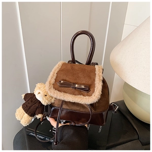Close-up of retro brown suede backpack with faux fur trim and cute bear keychain detail