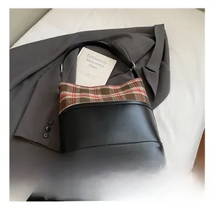 Detail of British vintage tote bag featuring matte black leather and plaid patchwork side