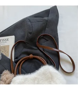 Detailansicht der weißen Plüschtasche mit braunen Lederriemen und süßem Bärenanhänger