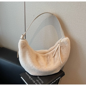Detail of plush crescent bag with soft faux fur texture and leather strap in beige