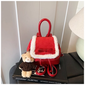 Detail of red bucket backpack with bow, fur trim, and a small brown bear plush charm