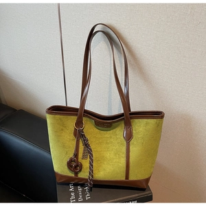 Dettaglio della borsa tote in pelle scamosciata verde oliva con finiture marroni