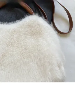 Detailaufnahme von flauschigem weißem Kunstpelz und kontrastierendem braunem Ledergriff