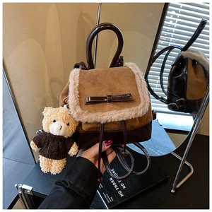Detailed view of brown bucket backpack with plush trim and cute teddy bear pendant