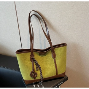 Dettaglio della borsa tote in pelle scamosciata verde con finiture in pelle marrone