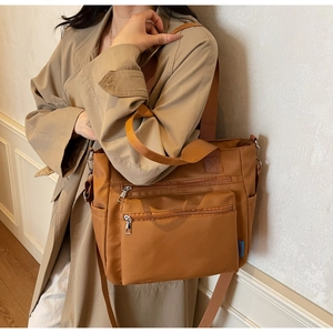 Détail du sac cabas en nylon terreux avec poches zippées et large bandoulière réglable