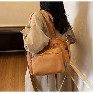 Sac fourre-tout en nylon marron vue de côté montrant plusieurs poches et sangle