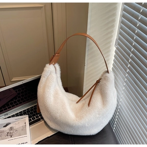 Close-up of a white plush hobo bag featuring brown leather strap and soft faux fur texture