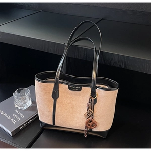 Dettaglio laterale della borsa tote grande in camoscio beige e pelle nera lucida