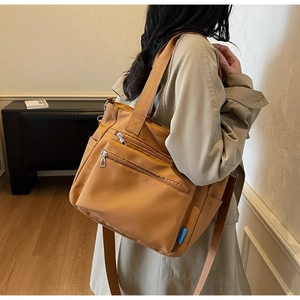 Détail du sac fourre-tout en nylon camel avec poches zippées et anses renforcées