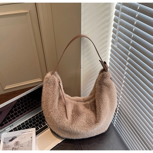 Detail of soft camel plush crescent bag with a dark brown leather shoulder strap