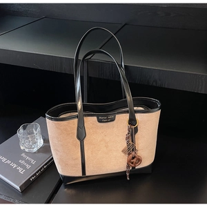 Dettaglio della borsa tote beige minimalista con bordo nero e logo del marchio