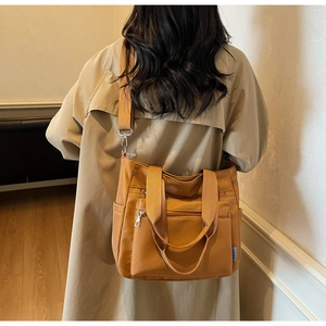 Vue latérale du sac fourre-tout en nylon camel avec plusieurs poches zippées et bandoulière
