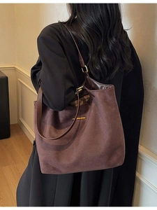 Grote bruine matte lederen shopper tas gedragen over een zwarte winterjas voor dames