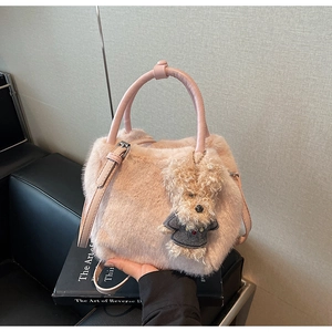 Detailansicht der rosa Plüschhandtasche mit Ledergriff und einem süßen Pudel-Anhänger