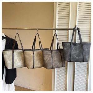 Detail of multi-colored marble pattern tote bags hanging on a rack with PU leather handles