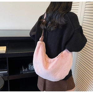 Close-up of pink fluffy hobo bag with plush faux fur texture and smooth leather strap