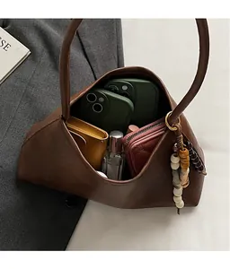 Interior view of the brown leather shoulder bag showing large capacity and wood bead charm