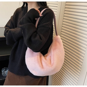 Detail of soft pink faux fur crescent shoulder bag with leather strap on female model