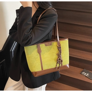 Dettaglio della borsa shopper verde avocado e marrone con nappa e logo di marca
