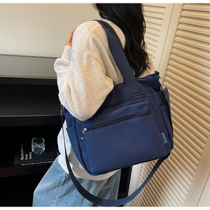 Détail du sac cabas en nylon bleu marine avec poches zippées et bandoulière réglable