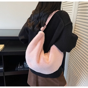 Detail of pink faux fur crossbody bag worn by model showing its soft texture and size