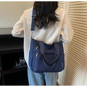 Détails du sac bandoulière en nylon bleu marine avec poches multiples et bandoulière