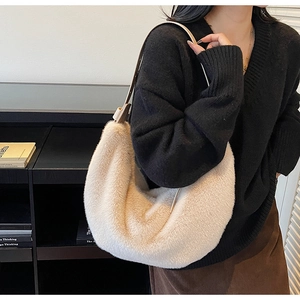 Close-up of fluffy cream plush shoulder bag with smooth thin leather strap detail