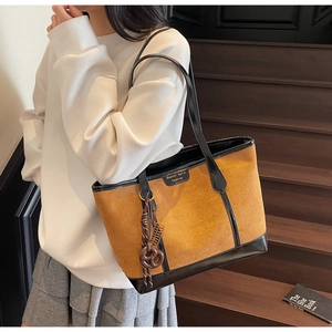 Dettaglio della borsa tote in camoscio caramello con logo del marchio e tessuto operato