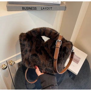 Detail von Leoparden-Kunstfell und verstellbarem braunem Leder-Schultergurt der Tasche