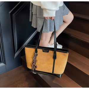 Dettaglio della borsa tote in pelle scamosciata giallo zenzero con finiture in pelle nera