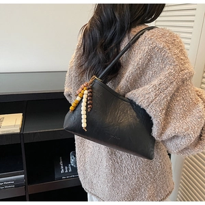Detail of black leather shoulder bag with Chio'2nd logo and colorful beaded tassel charm