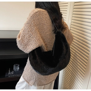 Detailed close-up of a soft black faux fur crescent bag on a model for winter style
