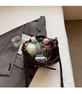 Dettaglio dell'interno spazioso di una borsa tote marrone con oggetti di uso quotidiano