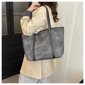 Detail shot of large tote bag with grey marble texture and black shoulder straps