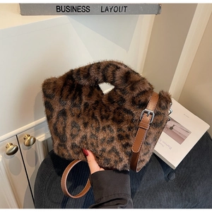 Detail der flauschigen Leopard-Fellstruktur und des braunen Lederriemens der Tasche