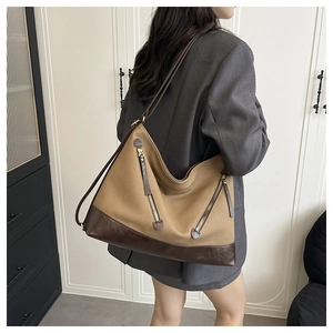 Detail view of the retro khaki canvas tote bag with brown leather straps and metal zippers