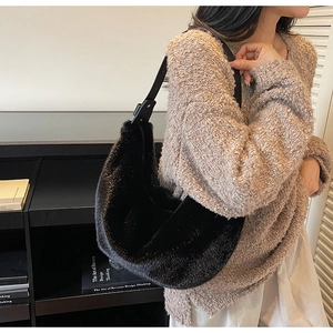Sac hobo noir en fausse fourrure chic avec bandoulière en cuir porté par un mannequin femme