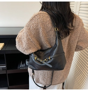 Dettaglio della borsa sottospalla vintage nera con fibbia dorata e accenti in pelle