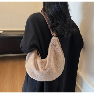 Detail of a beige plush hobo bag with soft faux fur texture and brown leather strap