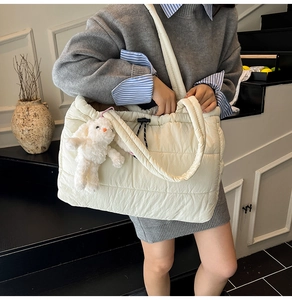 Quilted tote bag detail with plush rabbit charm and waterproof nylon material