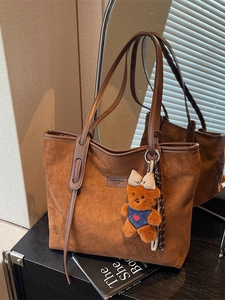 Brown matte suede tote bag with leather straps and a cute teddy bear charm