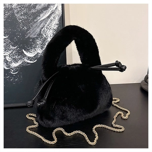 Details einer schwarzen Kunstpeltasche mit goldener Kette und Kordelzugverschluss