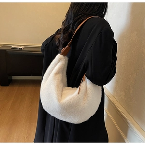 Detail of white faux fur shoulder bag with brown leather strap and soft winter texture