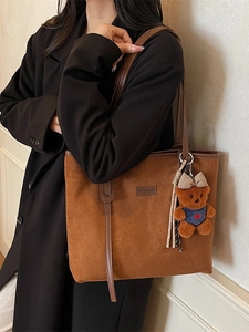 Brown matte suede tote bag with leather straps and cute plush bear charm for daily commute