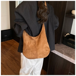 Vue détaillée du sac bandoulière en daim marron montrant la texture vintage et coutures