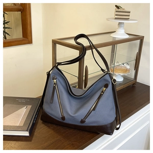 Close-up of canvas bucket bag with diagonal zipper pockets and premium leather trim